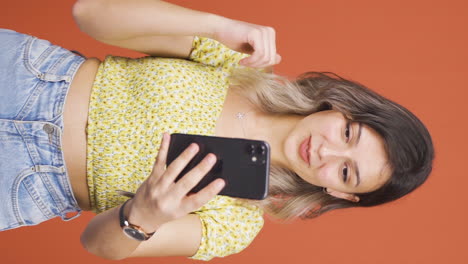 Vertical-video-of-Young-woman-making-a-video-call-on-the-phone.